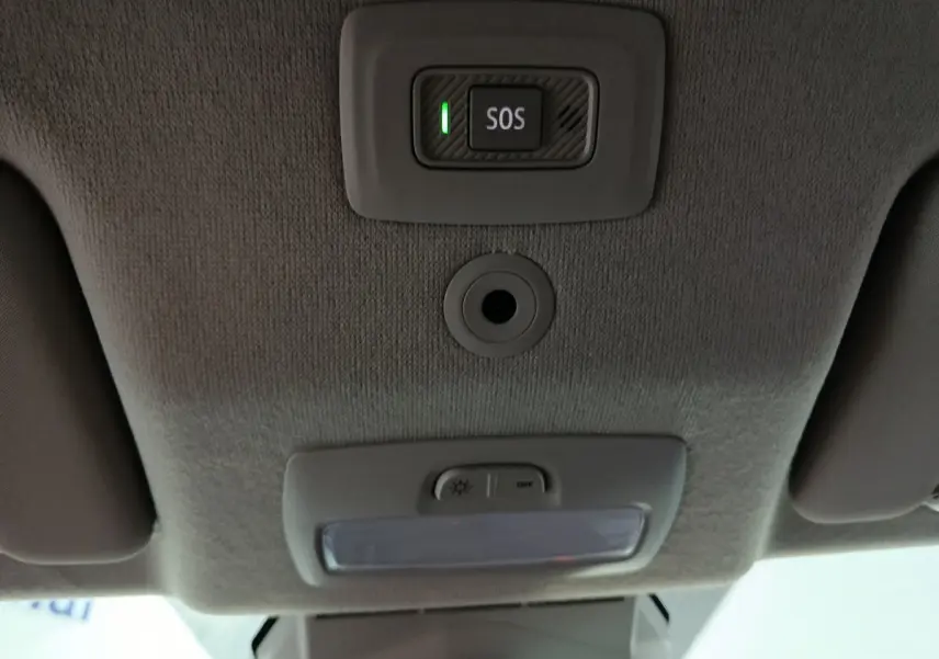 Vue intérieure du plafond de la Dacia Sandero 2024 avec bouton SOS éclairé et éclairage de cabine éteint.