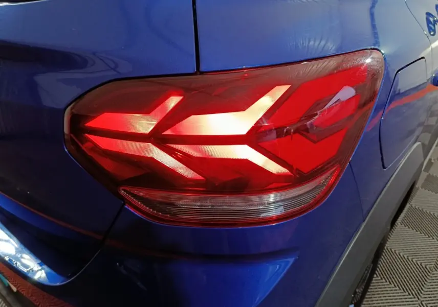 Gros plan sur le feu arrière droit rouge du Dacia Sandero Extreme+ bleu 2024, soulignant la carrosserie brillante.