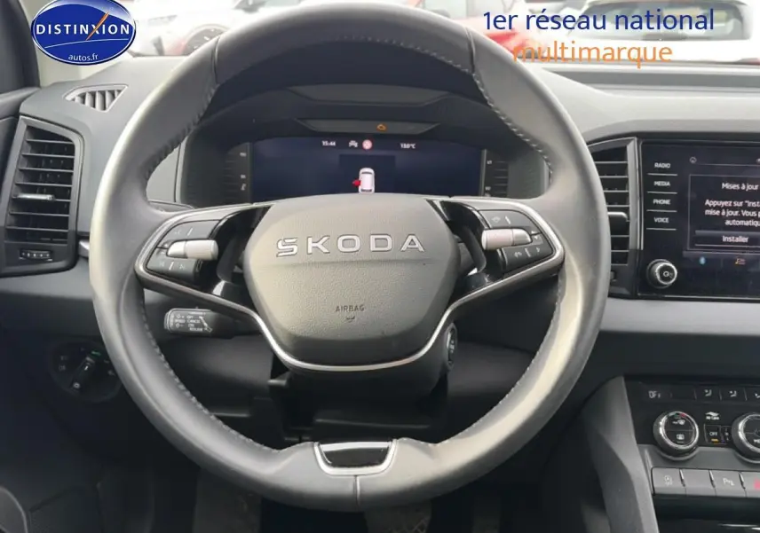 Vue rapprochée du volant cuir multifonction Skoda KAROQ 2025 avec tableau de bord numérique et écran tactile.