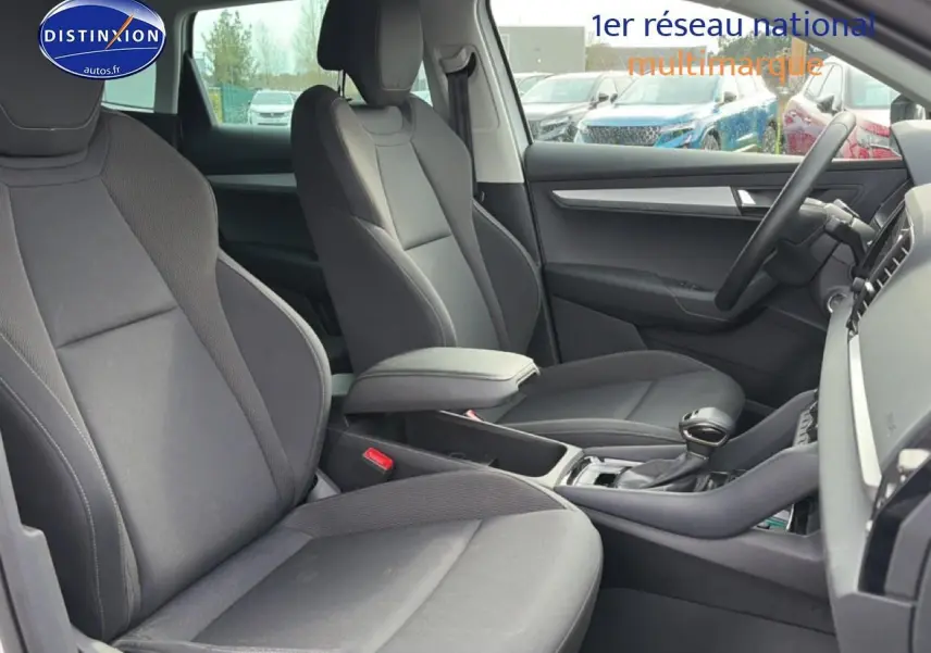 Intérieur avant du Skoda Karoq blanc glacial, vue côté droit sur sièges et console centrale avec accoudoir.