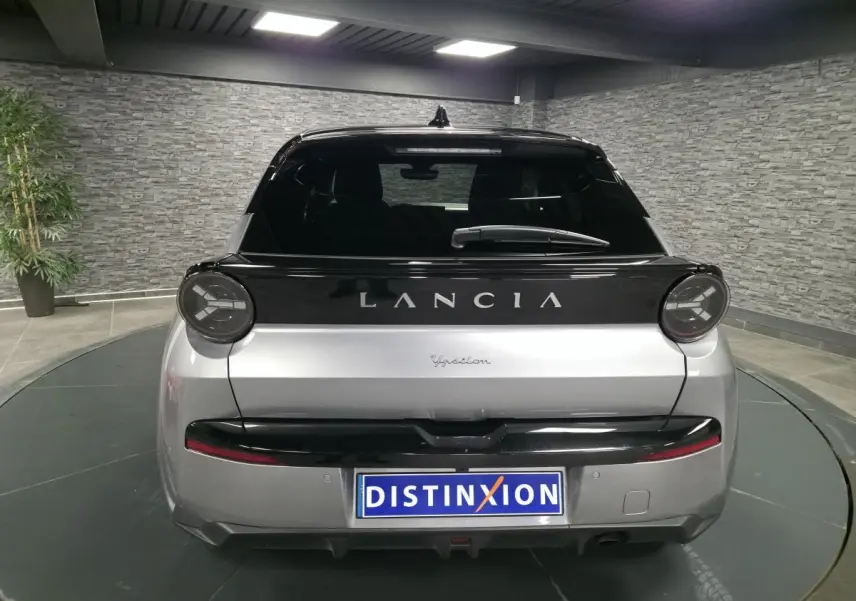 Vue arrière d'une Lancia Ypsilon 2025 bi-color gris et noir avec feux ronds et bandeau noir brillant.