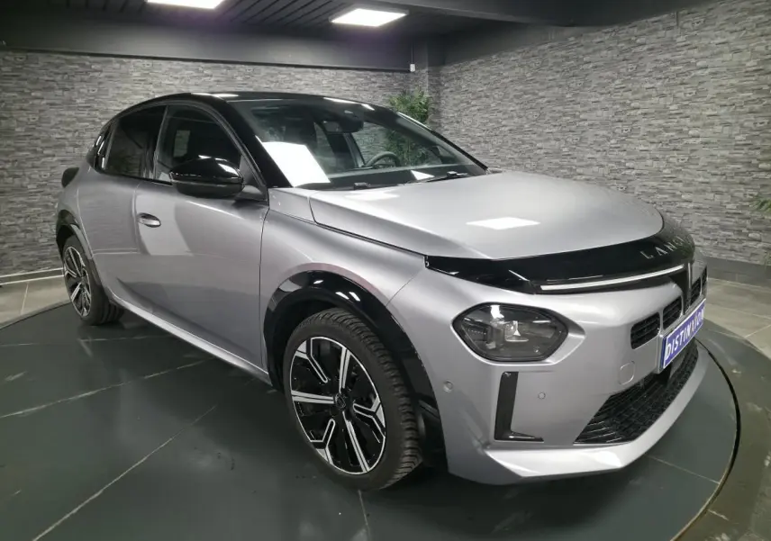 Lancia Ypsilon 2025 gris bi-color vue 3/4 avant droit avec toit noir et jantes alliage 17 pouces diamantées.