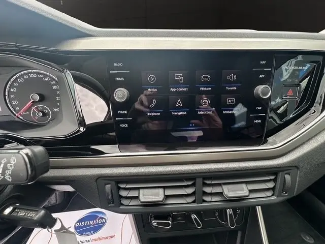 Vue rapprochée de l’écran tactile central multifonctions du tableau de bord d’une Volkswagen Polo gris clair 2021.