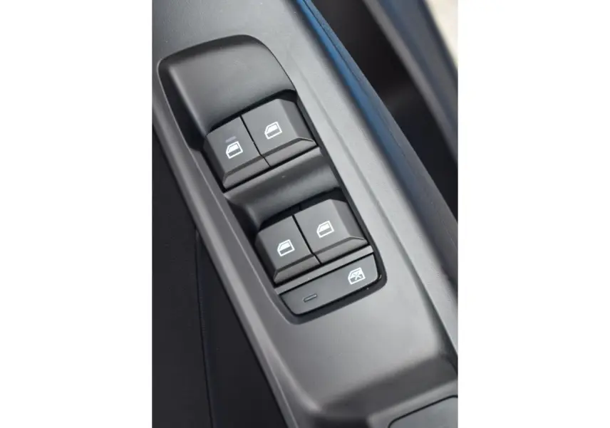 Gros plan sur les commandes des vitres électriques côté conducteur du MG3 1.5 L Hybrid+ 2026, intérieur noir.
