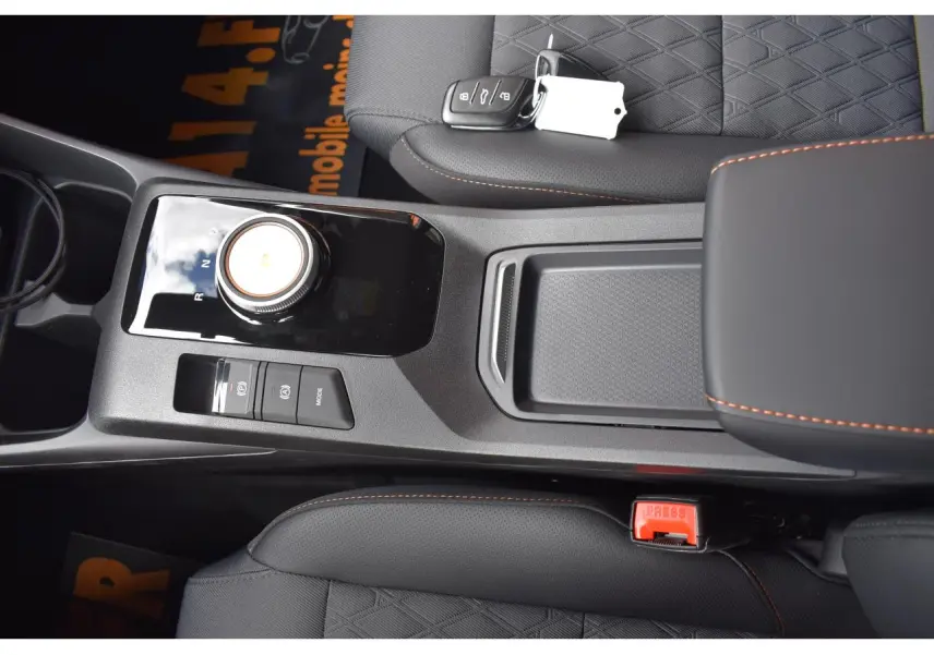 Vue plongeante sur la console centrale noire et les sièges noirs avec surpiqûres orange du MG3 Hybrid+ 2026, clé posée sur le siège.