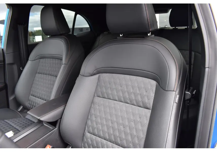 Gros plan sur les sièges avant en cuir noir avec surpiqûres orange du MG3 1.5 L Hybrid+ bleu, vue côté conducteur.