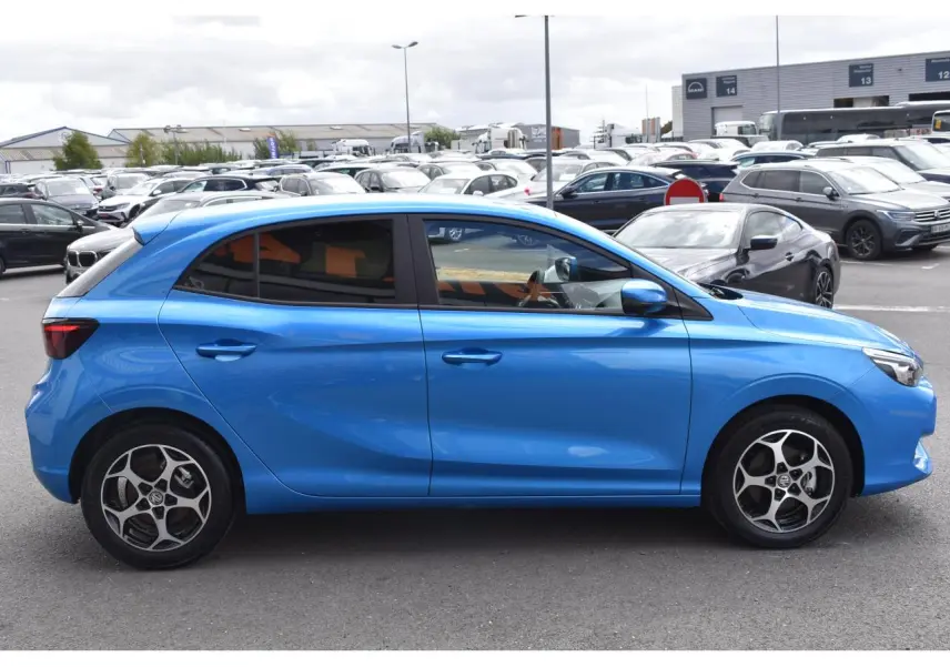 Vue de profil côté gauche d'une MG3 bleu métallisé avec jantes alliage et vitres surteintées sur parking.