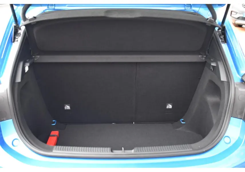 Coffre ouvert vu de l'arrière d'une MG3 1.5 L Hybrid+ bleu métallisé, montrant l'espace de chargement vide.