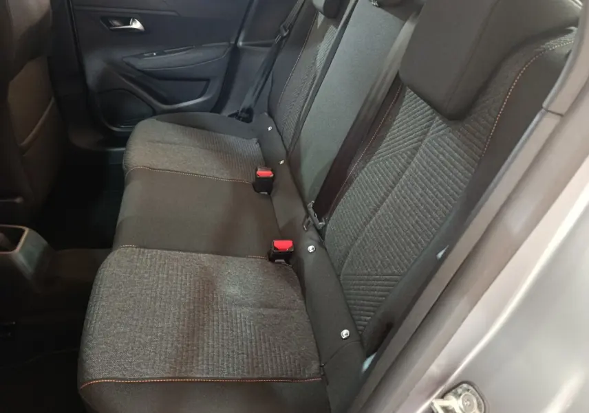 Vue latérale intérieure montrant la banquette arrière grise à trois places de la Peugeot 208 Hybrid 2025.