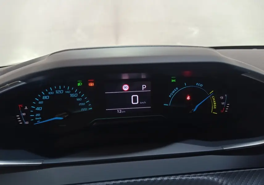 Vue rapprochée du combiné d'instruments numérique de la Peugeot 208 Hybrid 100 e-DCS6 Style, affichage multifonctions allumé.