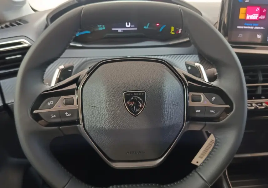 Volant cuir noir de Peugeot 208 Hybrid 2025 vu de face avec commandes multifonctions et tableau de bord numérique.