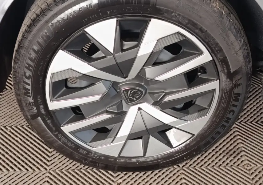 Gros plan sur la jante avant droite gris clair de la Peugeot 208 Hybrid 100 e-DCS6 Style avec logo lion central.