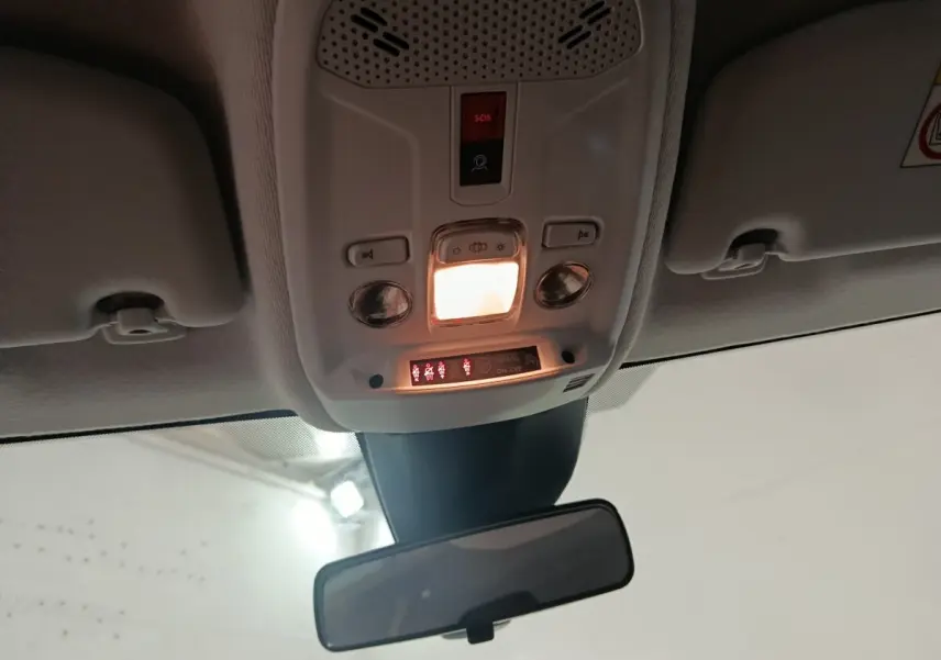 Vue intérieure du plafond avant du Peugeot 208 Hybrid 100 e-DCS6 Style 2025 avec éclairage et boutons SOS activés.