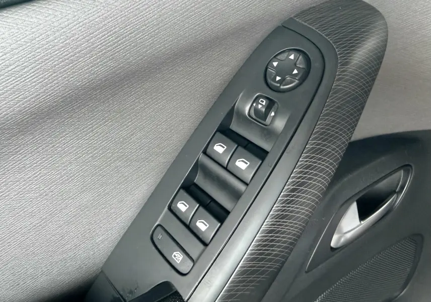 Gros plan sur la commande des vitres électriques et rétroviseurs côté conducteur de la Citroën C4 Picasso gris platinium.