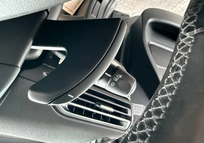 Gros plan sur la commande d'éclairage et la sortie d'air côté gauche du tableau de bord d'une Citroën C4 Picasso gris platinium.