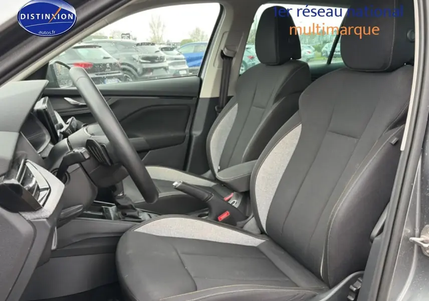 Vue intérieure côté conducteur du Skoda Kamiq gris 2025, sièges tissu bicolores noirs et gris avec coutures contrastées.