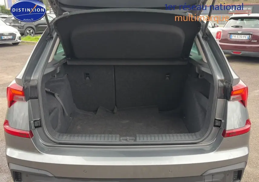 Coffre ouvert vu de l'arrière d'un Skoda Kamiq gris 2025 avec feux arrière LED et hayon relevé.