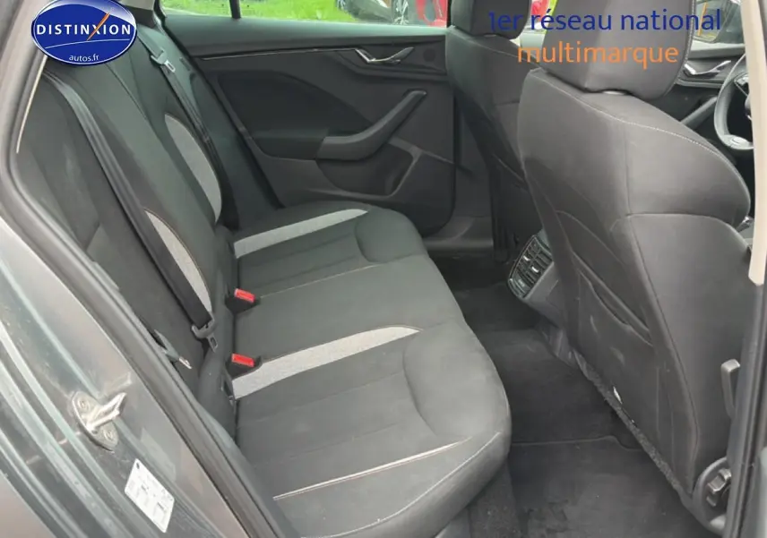 Vue intérieure arrière côté gauche du Skoda Kamiq gris, montrant les sièges tissu bicolores et les aérateurs arrière.