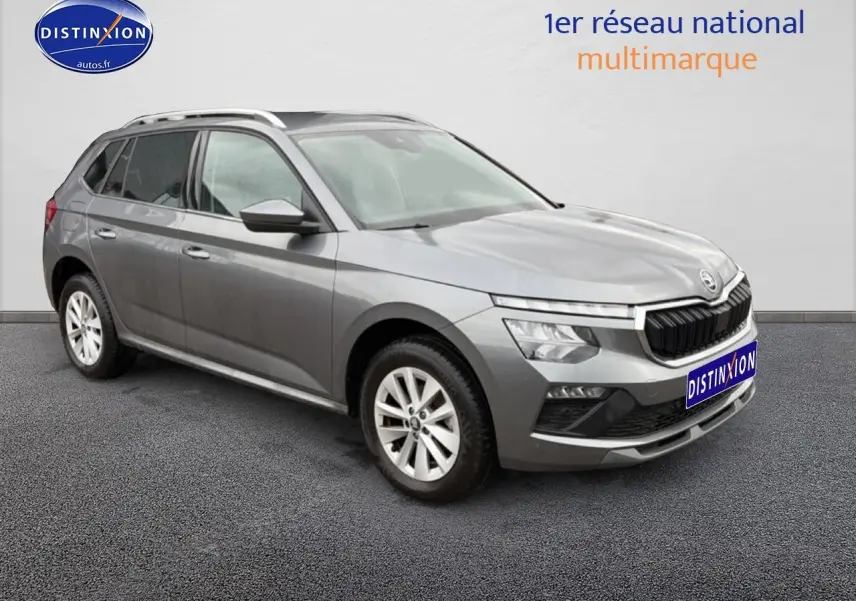 Vue 3/4 avant gauche d'un Skoda Kamiq gris avec calandre chromée et barres de toit visibles.