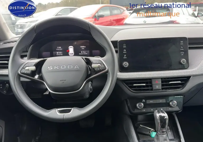 Intérieur de Skoda Kamiq 2025, vue du poste de conduite avec volant cuir et écran tactile central.