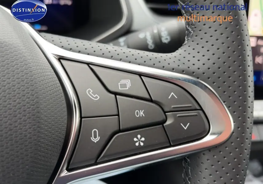 Gros plan sur les commandes noires du volant perforé côté gauche du Renault Symbioz bleu mercure.