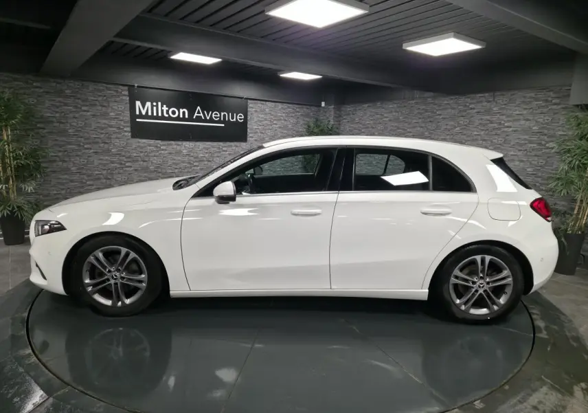 Profil côté gauche d'une Mercedes Classe A 160 Style Line blanche, avec jantes alliage 17 pouces gris Himalaya.
