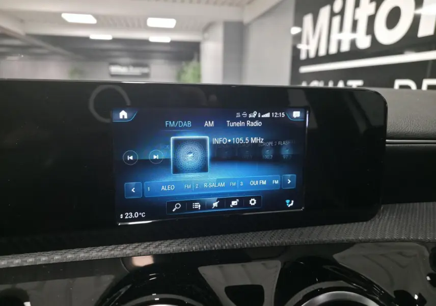 Écran tactile central MBUX affichant la radio numérique dans l'habitacle d'une Mercedes Classe A blanche.