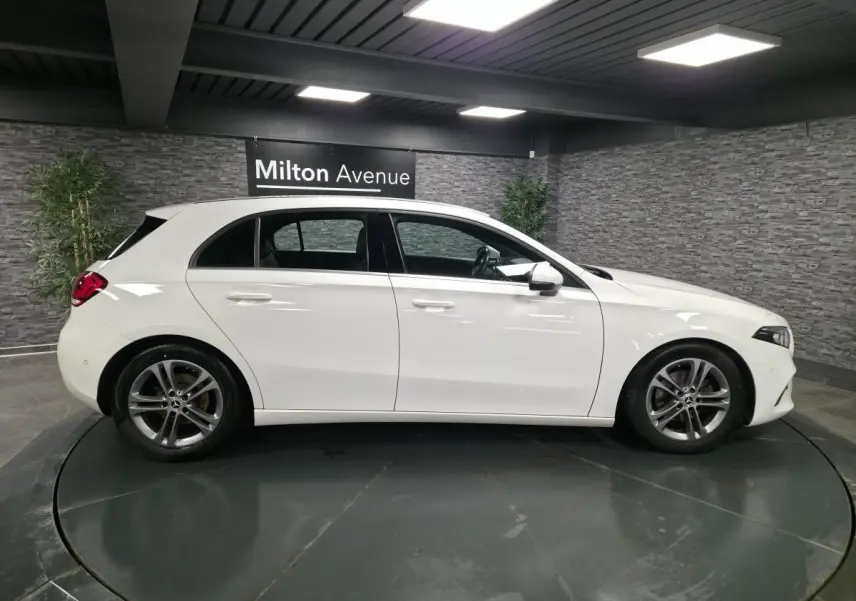 Vue de profil côté gauche d'une Mercedes Classe A 160 Style Line blanche avec jantes alliage 17 pouces gris Himalaya.