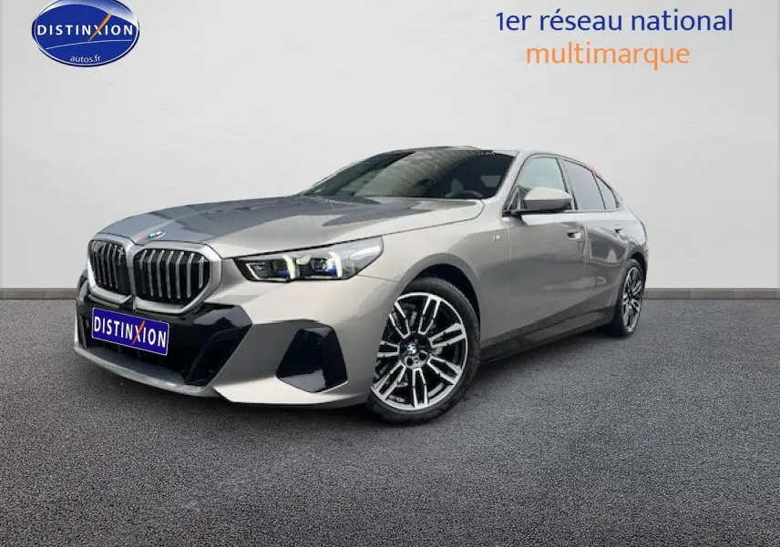 BMW Série 5 (G60) 520da gris vue 3/4 avant avec calandre imposante et jantes alliage sport.