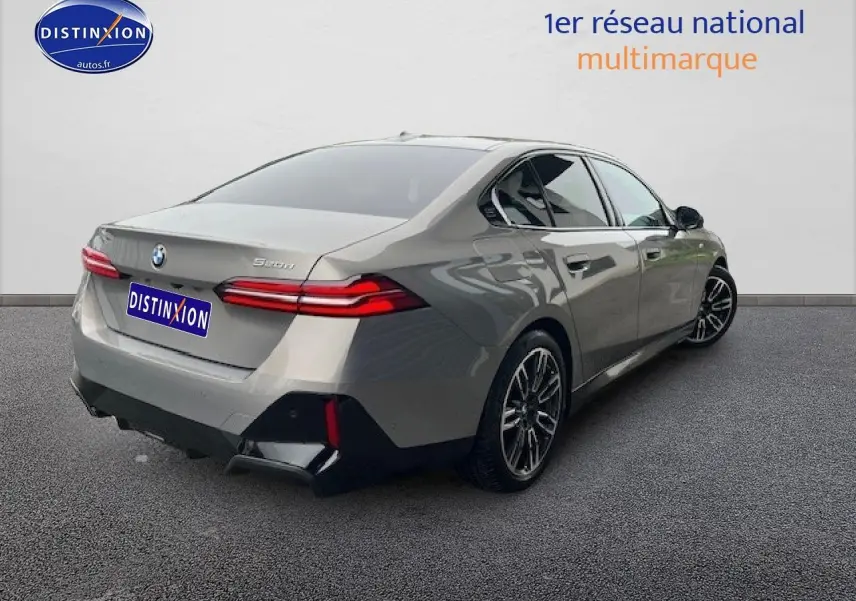 BMW Série 5 (G60) 520da gris vue 3/4 arrière droit, feux LED et jantes alliage sport visibles.