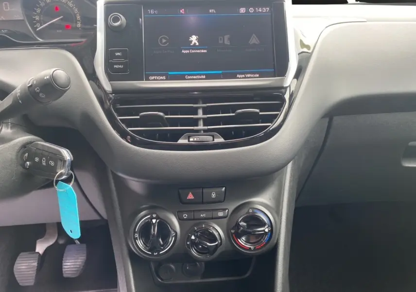Vue rapprochée du tableau de bord noir de la Peugeot 208 AFFAIRE 2019 avec écran tactile et commandes manuelles de climatisation.