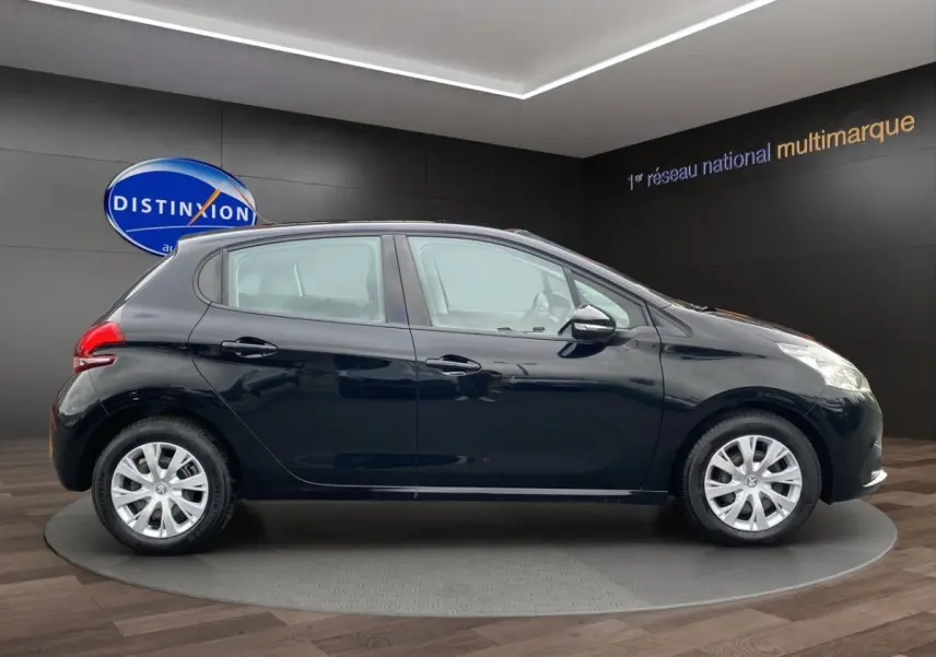 Peugeot 208 AFFAIRE noir vue de profil côté gauche, sur plateau en showroom avec logo Distinxion en arrière-plan.