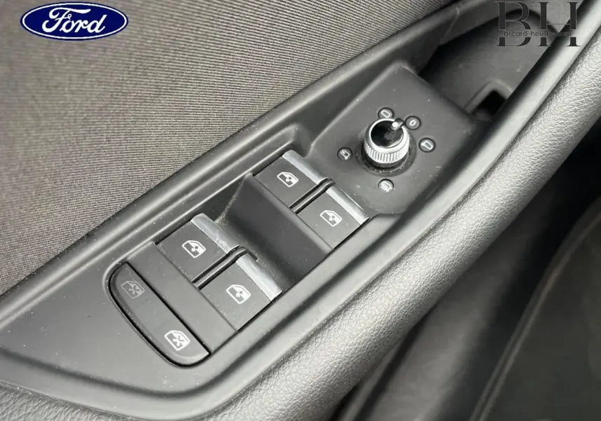 Gros plan sur les commandes des vitres électriques et rétroviseurs côté conducteur d'une Audi A4 Avant gris Manhattan.