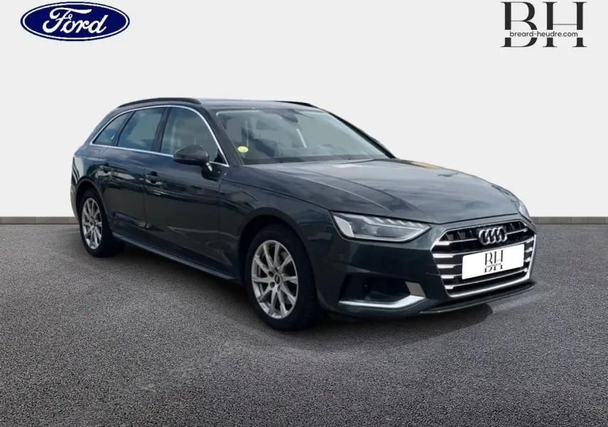 Audi A4 Avant 30 TDI gris Manhattan métallisé vue 3/4 avant avec jantes alu et barres de toit noires.