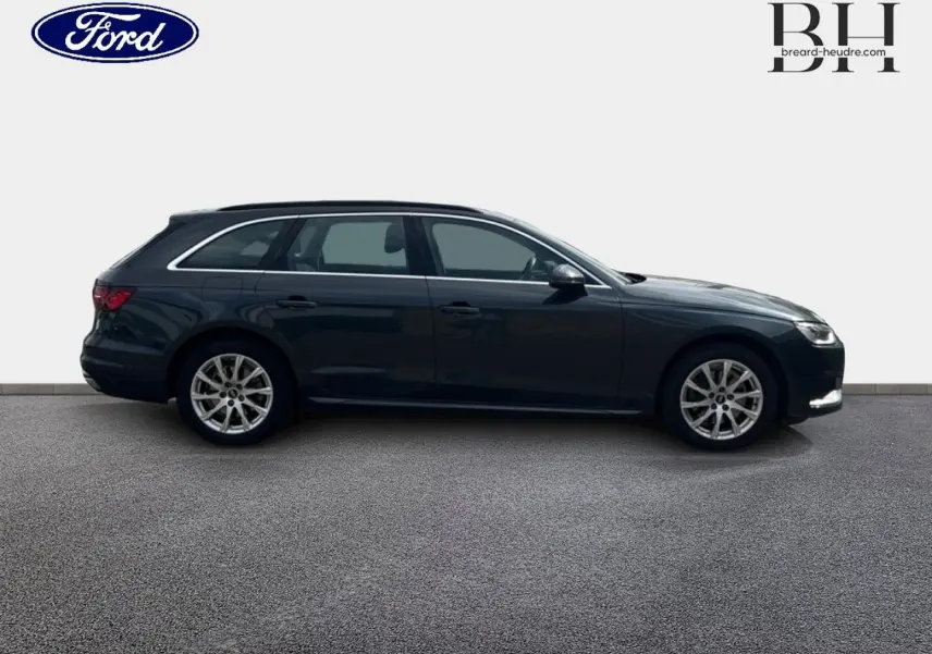 Profil droit d'une Audi A4 Avant 30 TDI Business line 2022 gris Manhattan métallisé avec jantes alu et barres de toit.