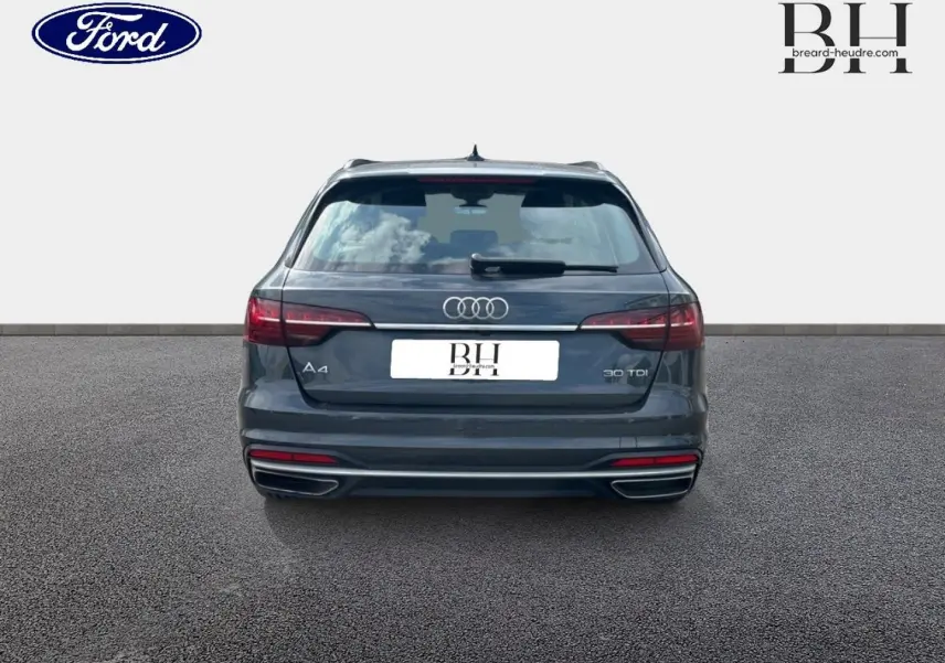 Vue arrière d'une Audi A4 Avant 30 TDI gris Manhattan métallisé, avec feux LED et double sortie d'échappement chromée.
