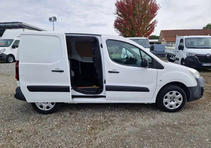 Peugeot Partner blanc vu de profil droit avec porte latérale coulissante ouverte montrant l'intérieur utilitaire.