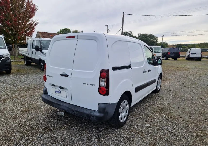 Vue 3/4 arrière droite d’un Peugeot Partner blanc 2017 utilitaire avec portes arrière battantes et attelage visible.