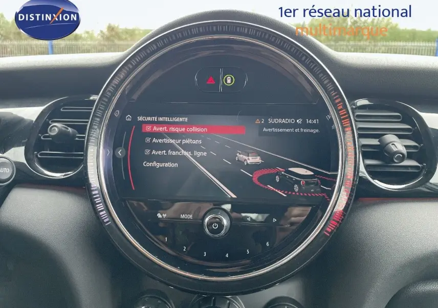 Vue rapprochée du tableau de bord de la MINI 2023, écran central rond affichant les alertes de sécurité, intérieur noir.