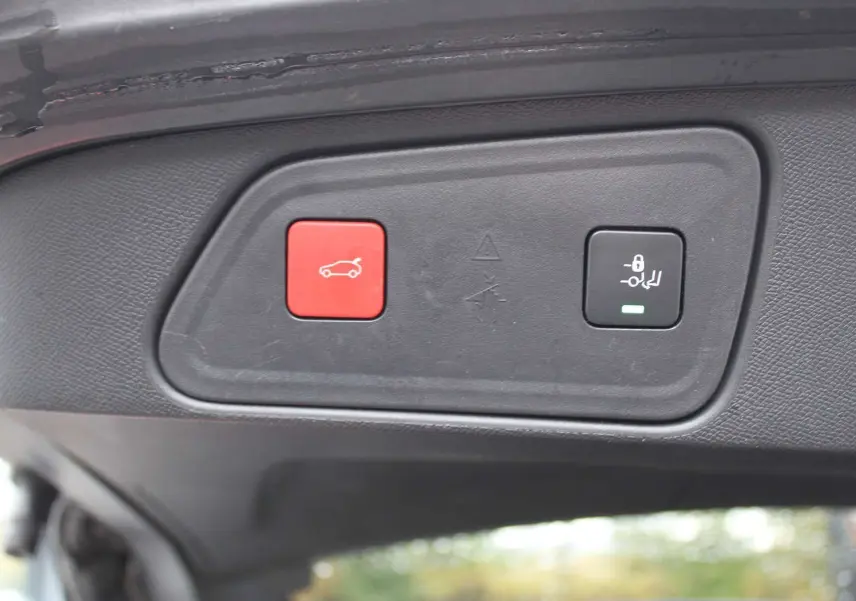 Boutons de commande du hayon électrique sur le bord intérieur du coffre du Peugeot 3008 blanc nacré 2025.