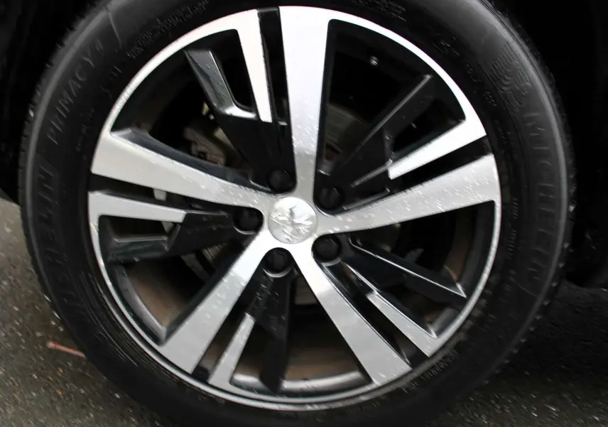 Gros plan sur la jante alliage bicolore du Peugeot 3008 blanc nacré, soulignant son design moderne et élégant.