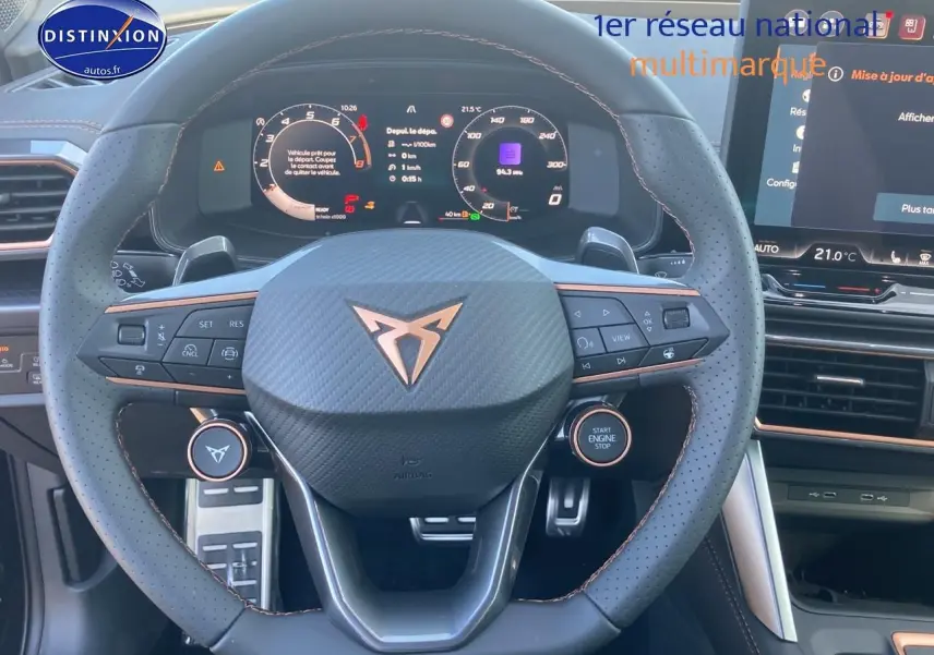 Vue intérieure centrée sur le volant sport cuir noir avec logo Cupra et tableau de bord numérique lumineux.