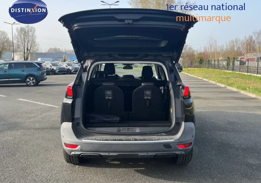 Vue arrière d’un Peugeot 5008 noir Perla Nera avec hayon ouvert montrant le coffre et les sièges arrière.