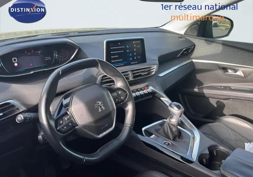 Vue intérieure du poste de conduite du Peugeot 5008 noir Perla Nera, avec volant compact et levier de vitesse manuel.
