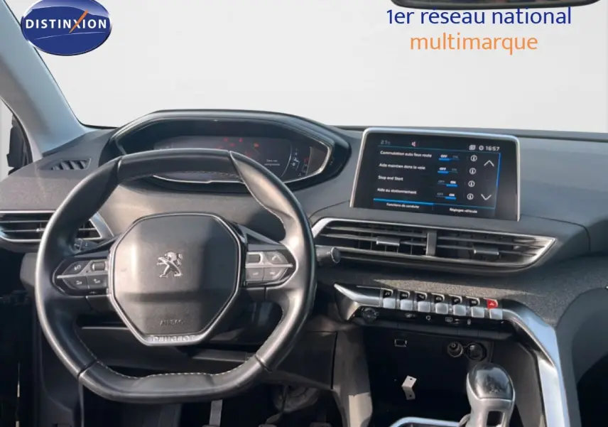 Vue intérieure du tableau de bord et volant Peugeot 5008 noir, avec écran tactile central et commandes modernes.