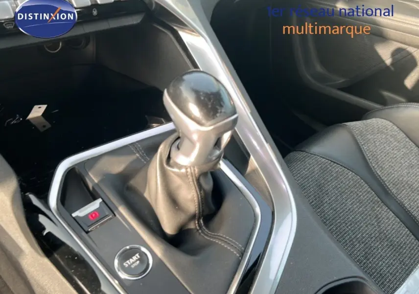 Le levier de vitesse manuel en cuir noir au centre de la console d'une Peugeot 5008 noire, avec bouton start/stop visible.