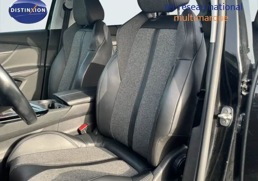 Vue intérieure côté conducteur du Peugeot 5008 noir Perla Nera, mettant en valeur les sièges mixtes tissu gris et cuir noir.
