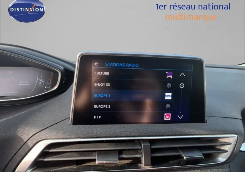 Vue intérieure du tableau de bord du Peugeot 5008 noir, avec écran central affichant les stations radio.