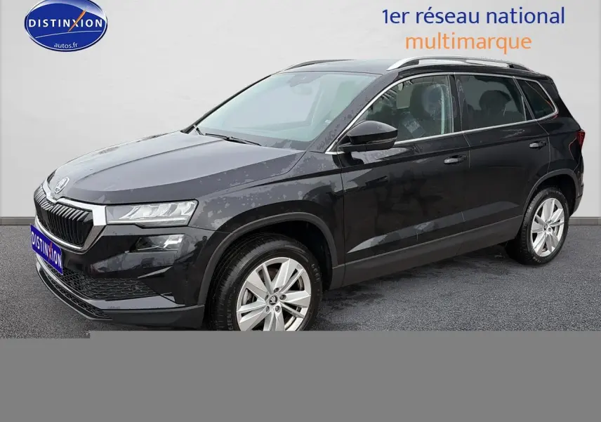 Vue 3/4 avant droite d’un Skoda Karoq noir 2025 avec jantes alu et barres de toit visibles.