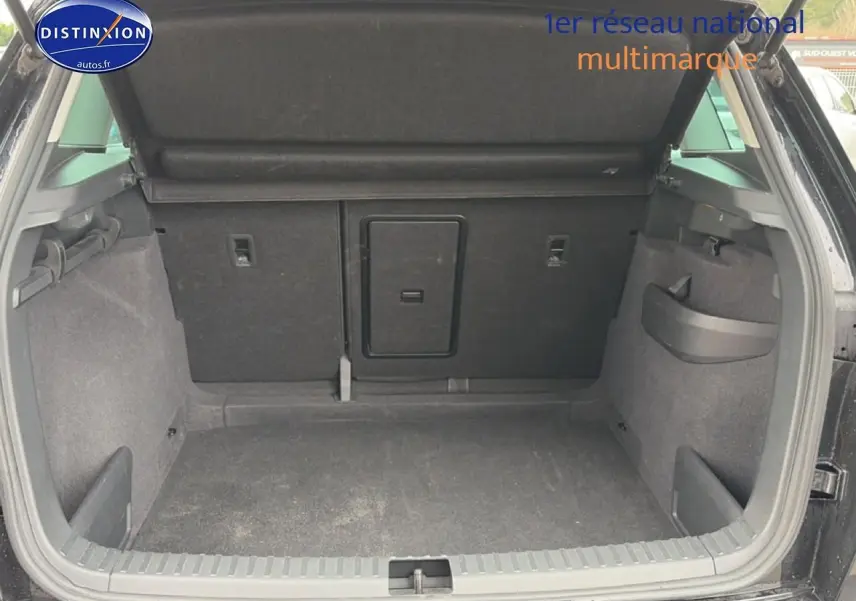 Coffre ouvert vu de l'arrière d'un Skoda Karoq noir, montrant un espace de chargement propre et fonctionnel.